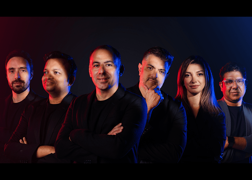 Think Human leadership team photographed against a red and blue lit background